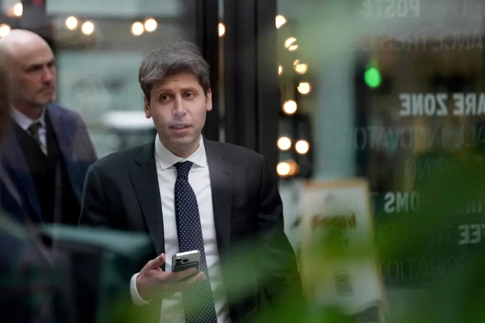 OpenAI 首席執行官 Sam Altman 正在看他的手機。OpenAI 的 Sam Altman 的一些員工跳槽到了 Meta。 圖片來源： aurelien morissard/路透社